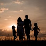 a family standing in a field at sunset