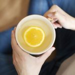 a person holding a cup of liquid